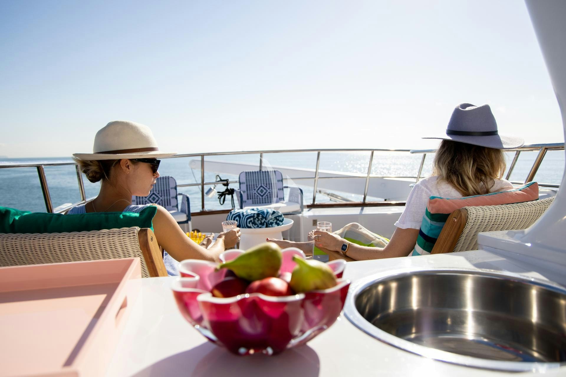 a couple of women sitting at a table with a bowl of fruit aboard SEA BREEZE III Yacht for Charter