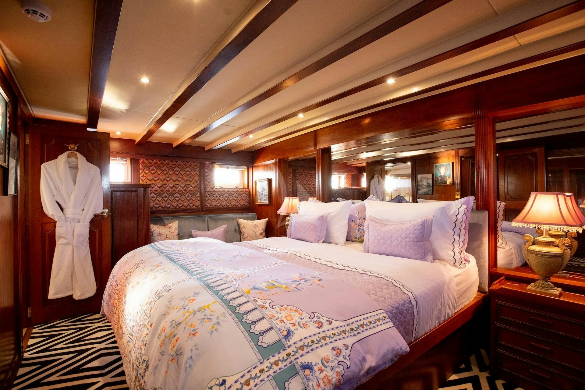 a bedroom with a bed and a lamp aboard SEA BREEZE III Yacht for Charter