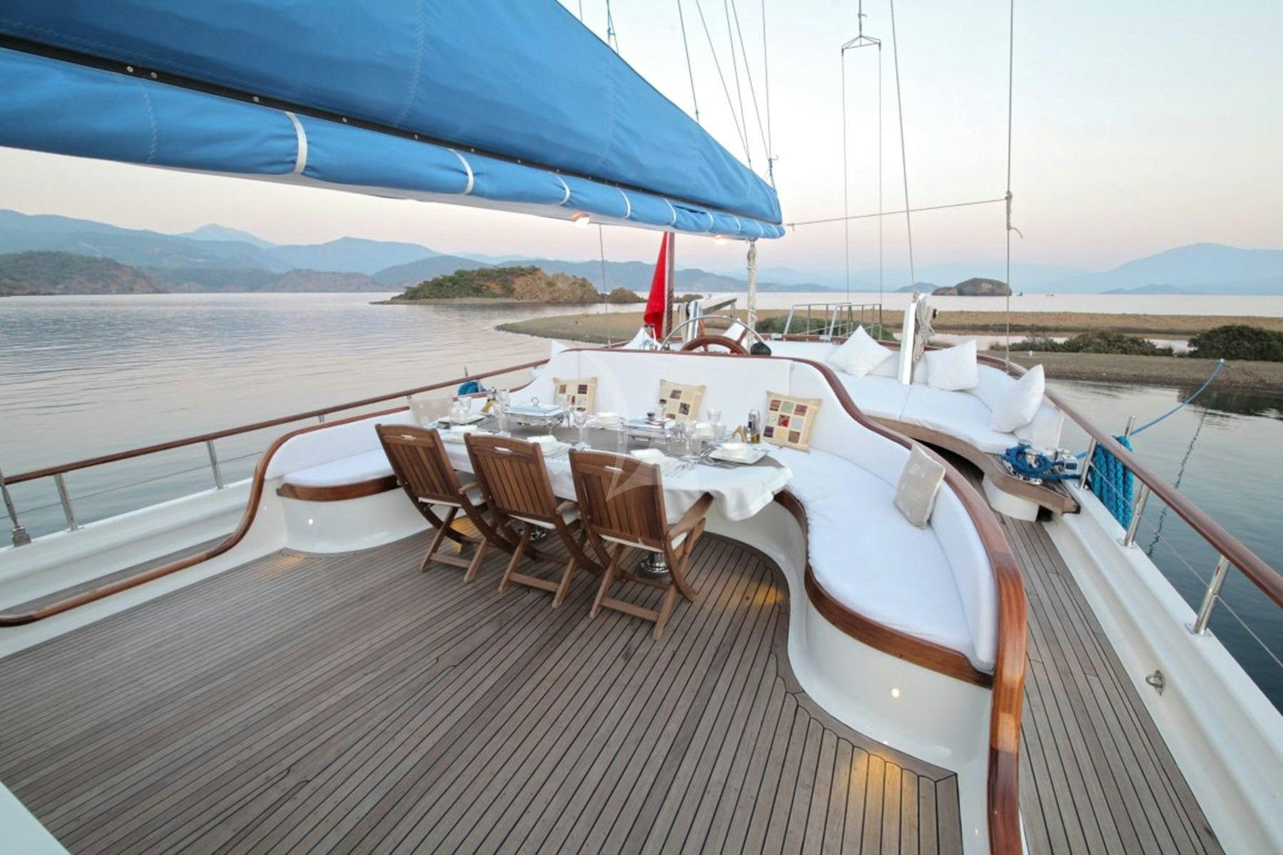 a deck with tables and chairs on it aboard ECE BERRAK Yacht for Charter