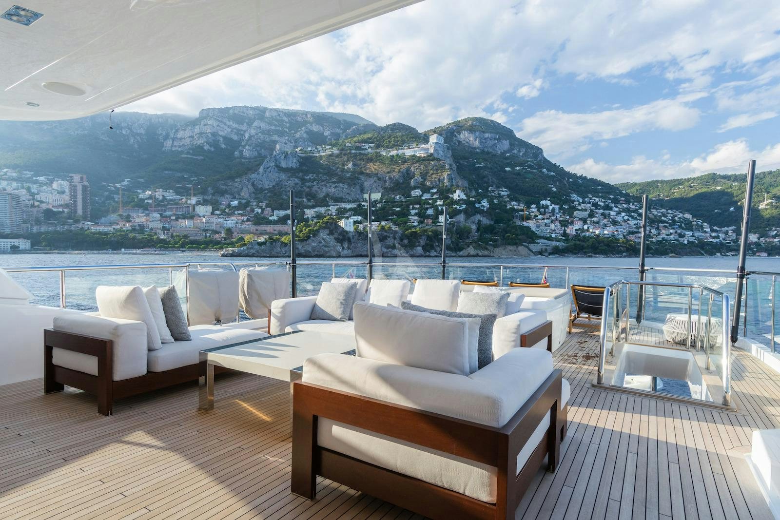 a deck with a view of a city and mountains aboard MINOR FAMILY AFFAIR Yacht for Charter