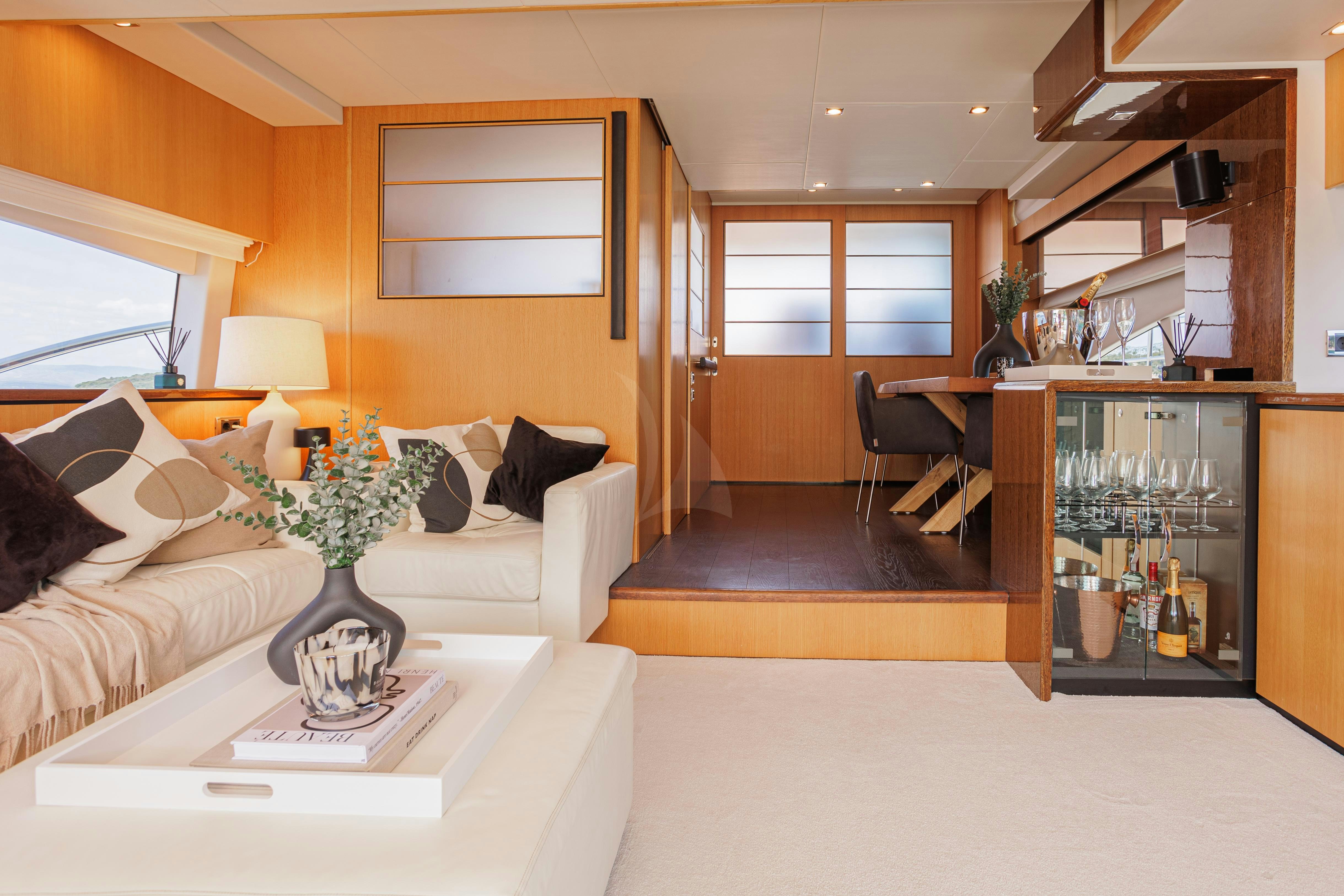 a living room with a white couch and a vase with flowers in it aboard JOLIDOR Yacht for Charter