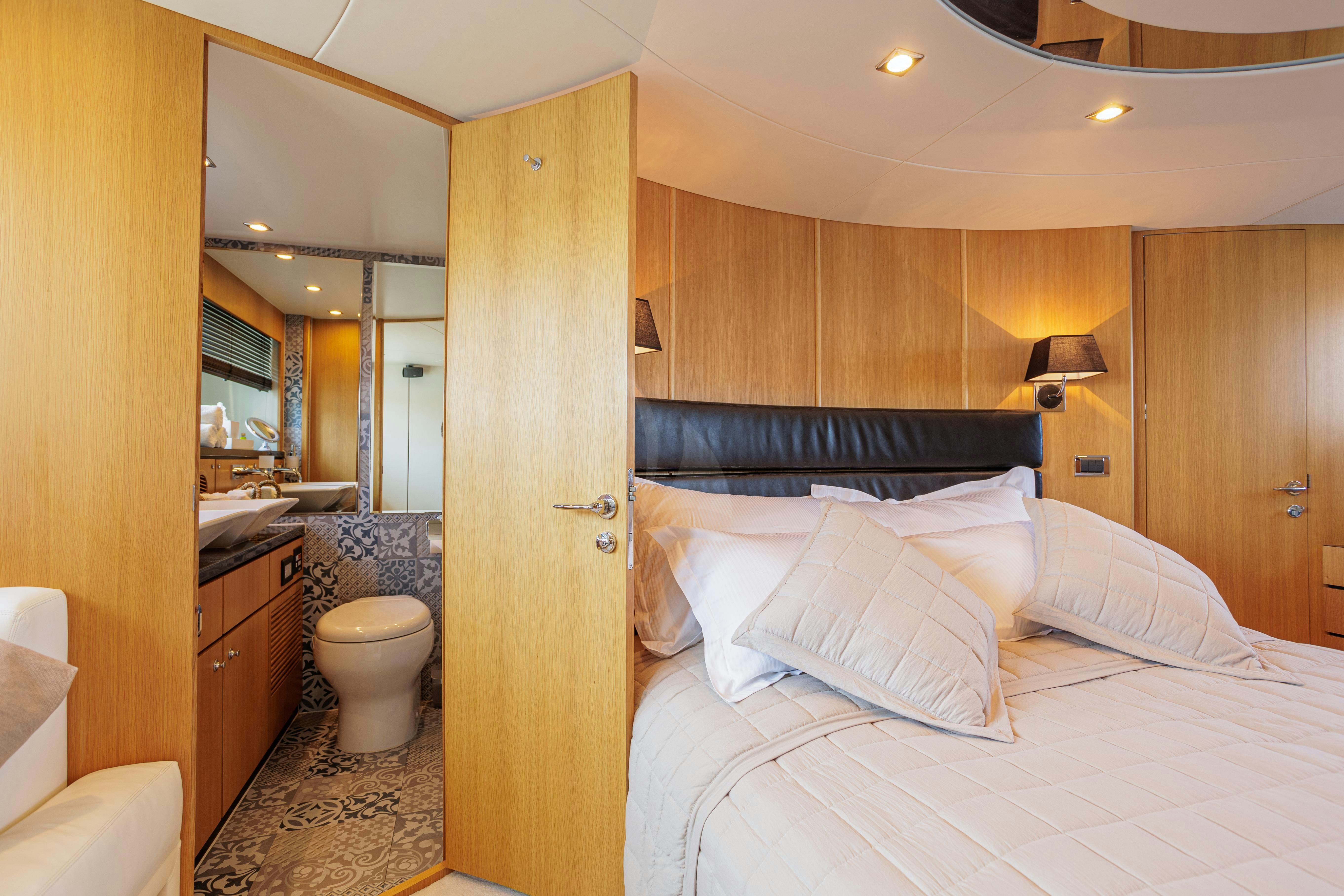 a bedroom with a bed and a mirror aboard JOLIDOR Yacht for Charter