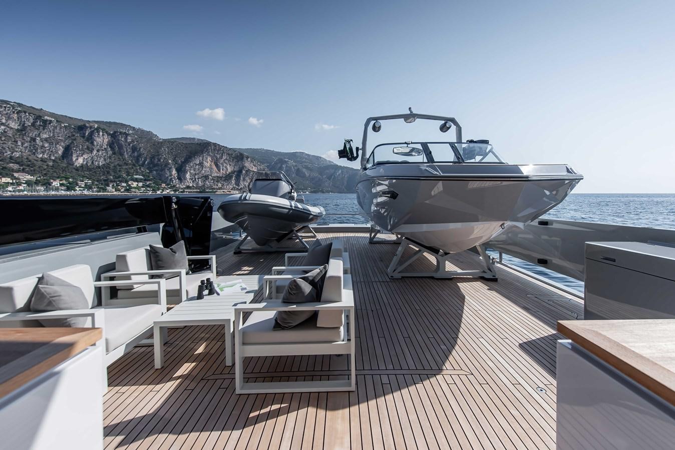 a boat on a deck with USS Iowa (BB-61) in the background aboard CROSSOVER 27M Yacht for Sale
