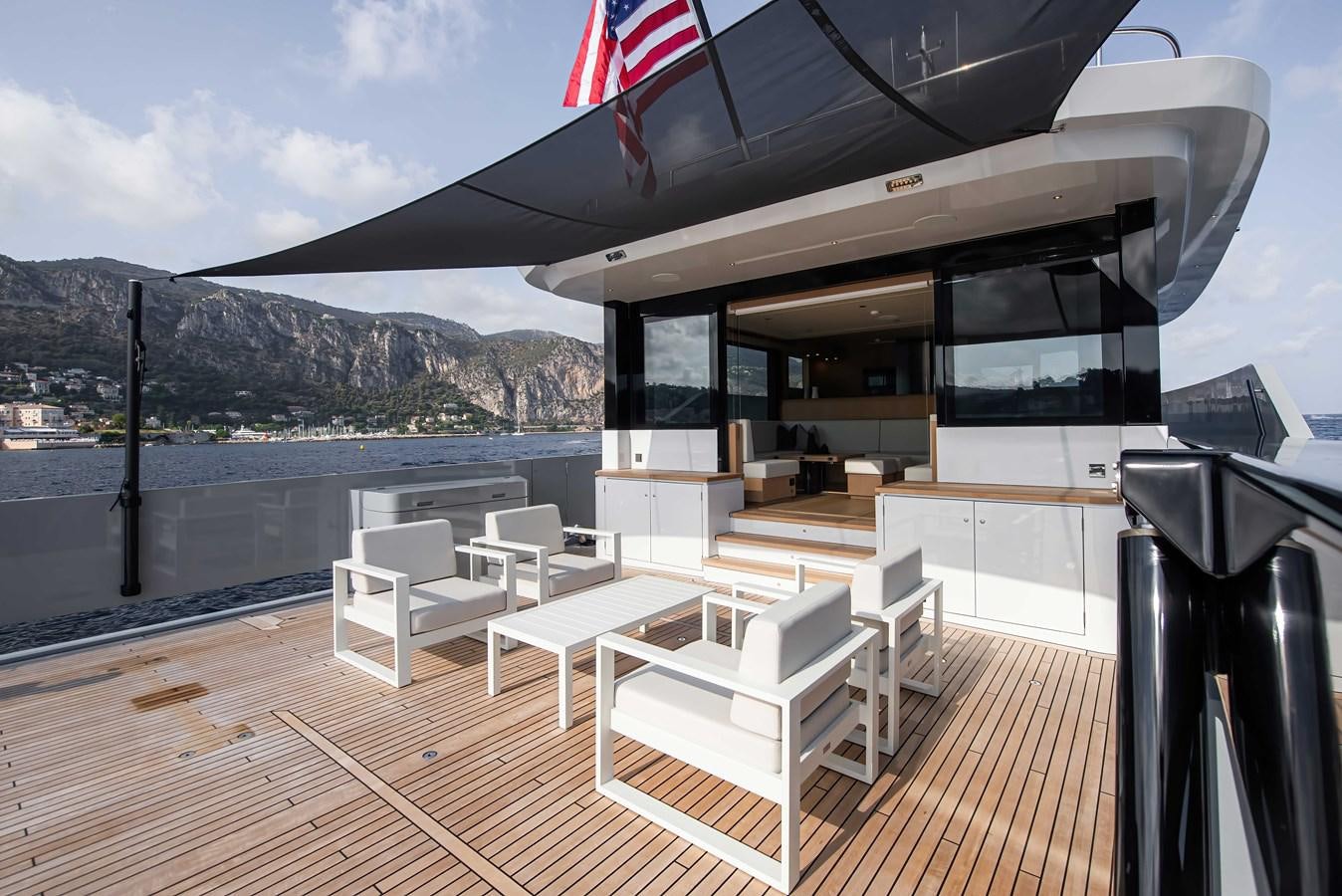 a deck with a deck and chairs on it aboard CROSSOVER 27M Yacht for Sale