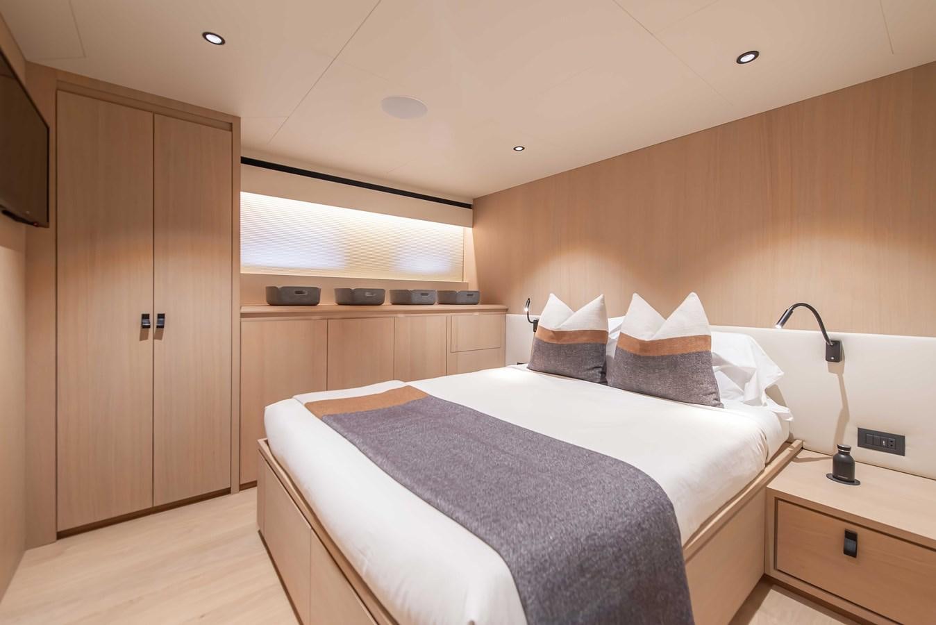 a bedroom with a bed and a desk aboard CROSSOVER 27M Yacht for Sale