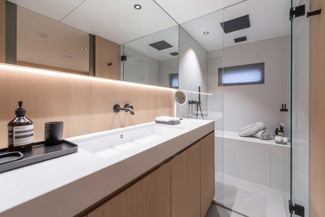 a bathroom with a glass shower aboard CROSSOVER 27M Yacht for Sale