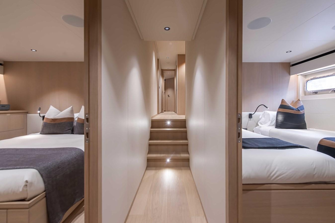a room with a bed and a wood door aboard CROSSOVER 27M Yacht for Sale