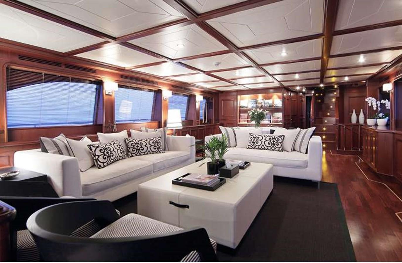a living room with a large white couch and a large window aboard LADY SOUL Yacht for Charter